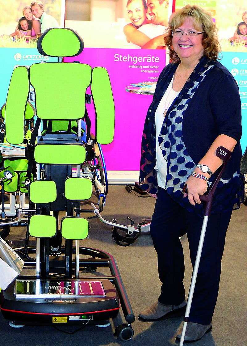Frau steht mit Krücken neben einem technischen Gerät