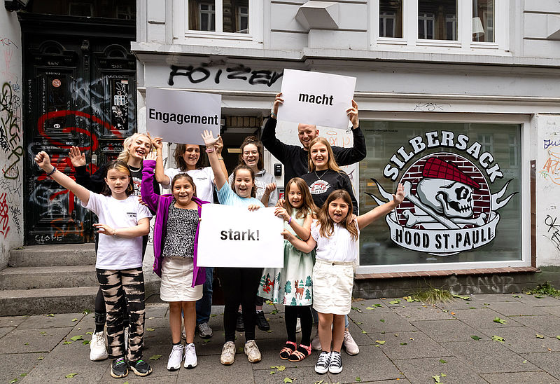 Kinder und Ehrenamtliche der Sprachförderung vor den Projekträumen