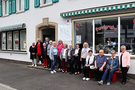 17 Ehrenamtliche Helfer*innen vor dem Laden