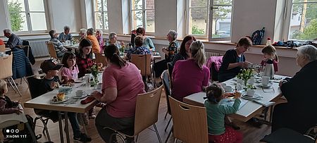 Menschen sitzen am gedeckten Tisch